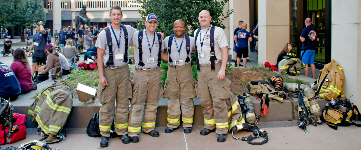 Four firemen lined up in their firefighter gear.