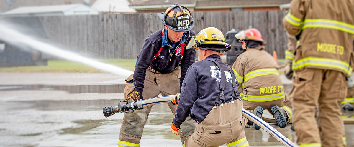 Firefighters training with fire hose.