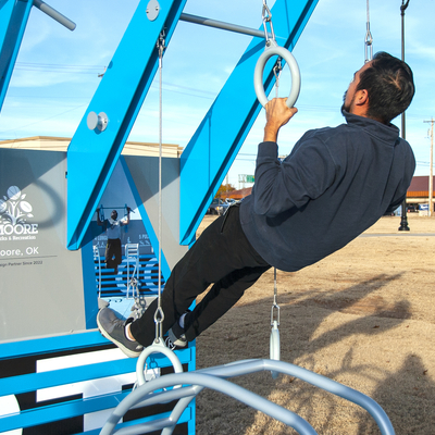 Person doing pull-ups on the rings on the Fitness Court